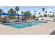 Outdoor pool and spa area featuring blue picnic tables and shady palm trees at 9501 E Broadway Rd # Ofc, Mesa, AZ 85208