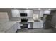Bright kitchen with stainless steel appliances, white cabinets, marble countertops and new grey plank floors at 9632 E Arbor Cir, Mesa, AZ 85208