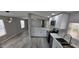 Kitchen featuring stainless appliances, white shaker cabinets, marble countertops, and new grey plank floors at 9632 E Arbor Cir, Mesa, AZ 85208