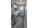 Laundry room with modern washer and dryer, overhead cabinets, and a door to the exterior at 9632 E Arbor Cir, Mesa, AZ 85208