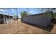View of the detached, metal storage building in the backyard, partially framed with a metal support structure at 9632 E Arbor Cir, Mesa, AZ 85208