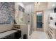 Bathroom with a soaking tub, glass-enclosed shower, and decorative accent wall at 9675 E Roadrunner Dr, Scottsdale, AZ 85262