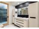 Modern bathroom featuring a double vanity, black hardware, a unique frosted glass door, and clean lines at 9675 E Roadrunner Dr, Scottsdale, AZ 85262