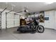 Spacious garage with epoxy flooring, storage cabinets, and a sleek motorcycle at 9675 E Roadrunner Dr, Scottsdale, AZ 85262