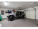 Well-organized garage featuring epoxy flooring and a rugged silver Jeep Wrangler at 9675 E Roadrunner Dr, Scottsdale, AZ 85262
