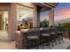 Outdoor bar with seating, stone accents, and views into the home's interior at 9675 E Roadrunner Dr, Scottsdale, AZ 85262