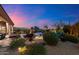 Landscaped backyard featuring a luxurious pool and spa area at twilight at 9675 E Roadrunner Dr, Scottsdale, AZ 85262