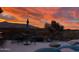 Backyard view of a colorful sunset, featuring a pool, seating, and desert landscape at 9675 E Roadrunner Dr, Scottsdale, AZ 85262