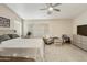 Cozy bedroom with a queen bed, ceiling fan, and comfortable sitting area at 1072 W Windhaven Ave, Gilbert, AZ 85233