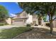 Two-story home with beige stucco, a red tile roof, a two car garage and a well-manicured lawn at 1072 W Windhaven Ave, Gilbert, AZ 85233