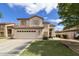 Two-story home with beige stucco, a red tile roof, a two car garage and a well-manicured lawn at 1072 W Windhaven Ave, Gilbert, AZ 85233