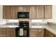 Kitchen with wooden cabinets, black appliances, and ample counter space for meal prep at 1072 W Windhaven Ave, Gilbert, AZ 85233
