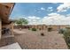 Large backyard with desert landscaping, patio area, block fencing, and beautiful blue sky at 10940 E Olla Ave, Mesa, AZ 85212