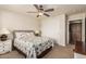 Cozy bedroom featuring a ceiling fan, neutral color palette, and closet with sliding doors at 10940 E Olla Ave, Mesa, AZ 85212