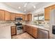 This kitchen features stainless steel appliances, wood cabinets and a window overlooking the yard at 10940 E Olla Ave, Mesa, AZ 85212