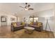 Bright living room featuring tile floors, two sofas with yellow throw pillows, and a ceiling fan at 10940 E Olla Ave, Mesa, AZ 85212