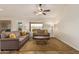 Bright living room featuring neutral sofas with yellow pillows and backyard view at 10940 E Olla Ave, Mesa, AZ 85212