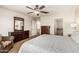 Spacious primary bedroom with ceiling fan, large dresser and a view into the ensuite bathroom at 10940 E Olla Ave, Mesa, AZ 85212