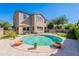 Backyard view with a sparkling pool, patio, landscaping, and a lush green artificial turf at 1128 E Phelps St, Gilbert, AZ 85295