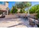 Backyard view with a covered patio, outdoor seating, lush greenery, and a spacious entertaining area at 1128 E Phelps St, Gilbert, AZ 85295