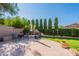 Relaxing backyard seating area with comfortable chairs, a fire pit, and lush landscaping at 1128 E Phelps St, Gilbert, AZ 85295