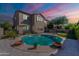 The backyard boasts a beautiful pool surrounded by travertine, perfect for entertaining with the covered patio and outdoor furniture at 1128 E Phelps St, Gilbert, AZ 85295