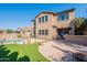 Backyard view showcasing the pool, landscaping, and outdoor living space with a covered patio at 1128 E Phelps St, Gilbert, AZ 85295