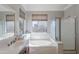 Bright bathroom featuring a large tub, shower, and vanity with sink at 1128 E Phelps St, Gilbert, AZ 85295