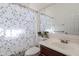 Functional bathroom featuring a triangular-patterned shower curtain, a single sink vanity, and a mirrored cabinet at 1128 E Phelps St, Gilbert, AZ 85295