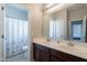 Bathroom with double sink vanity, large mirror, and shower with decorative curtain at 1128 E Phelps St, Gilbert, AZ 85295
