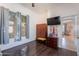 Bedroom featuring wood floors, a flat screen TV, a closet, and neutral walls with bright natural light at 1128 E Phelps St, Gilbert, AZ 85295