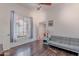 Bonus room featuring wood floors, a gray futon, a window, and a view into another area of the home at 1128 E Phelps St, Gilbert, AZ 85295