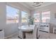 Bright dining area featuring white chairs, a table, three large windows and built in storage at 1128 E Phelps St, Gilbert, AZ 85295