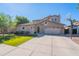 Inviting two-story home featuring a well-manicured lawn, three-car garage, and basketball hoop in the driveway at 1128 E Phelps St, Gilbert, AZ 85295