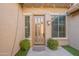 Stylish front entrance is decorated with plants, a neutral door, and outdoor lighting fixtures at 1128 E Phelps St, Gilbert, AZ 85295