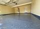 Spacious garage with epoxy flooring, ample lighting, and a convenient access door, providing a clean and functional space at 1128 E Phelps St, Gilbert, AZ 85295