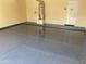 Clean garage featuring epoxy flooring, a water heater, and convenient access door, providing a functional space for storage at 1128 E Phelps St, Gilbert, AZ 85295