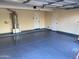 View of a spacious two car garage with blue epoxy floors and fresh paint at 1128 E Phelps St, Gilbert, AZ 85295