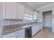 Kitchen featuring white cabinets, granite countertops, modern appliances and stylish backsplash at 1128 E Phelps St, Gilbert, AZ 85295