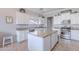Bright kitchen features white cabinets, stainless steel appliances, a tile backsplash, and a center island with granite countertops at 1128 E Phelps St, Gilbert, AZ 85295