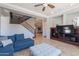 Living room with blue sofa, staircase, and entertainment center at 1128 E Phelps St, Gilbert, AZ 85295