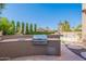 Outdoor kitchen with built-in grill, counter space, and stainless steel door overlooking the pool in the backyard at 1128 E Phelps St, Gilbert, AZ 85295