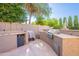 Spacious outdoor kitchen with built-in grill, sink, mini-refrigerator, and counter space for entertaining at 1128 E Phelps St, Gilbert, AZ 85295
