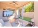Covered patio with TV, seating, and backyard access at 1128 E Phelps St, Gilbert, AZ 85295