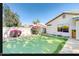 Backyard featuring synthetic grass putting green with bushes and a block wall for privacy at 13280 W Caribbean Ln, Surprise, AZ 85379