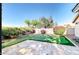 Backyard features lush desert landscaping, synthetic grass putting green, and a decorative stone patio at 13280 W Caribbean Ln, Surprise, AZ 85379