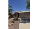 Single-story home with a two-car garage, desert landscaping, and walkway leading to the front door at 13280 W Caribbean Ln, Surprise, AZ 85379