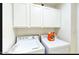White laundry room features washer, dryer, and white cabinets above for storage at 13280 W Caribbean Ln, Surprise, AZ 85379