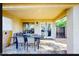Covered patio with travertine flooring and dining set, perfect for outdoor entertaining at 13280 W Caribbean Ln, Surprise, AZ 85379