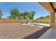 Backyard featuring gravel landscaping, a firepit, and a fenced pool area at 13724 W Luke Ave, Litchfield Park, AZ 85340